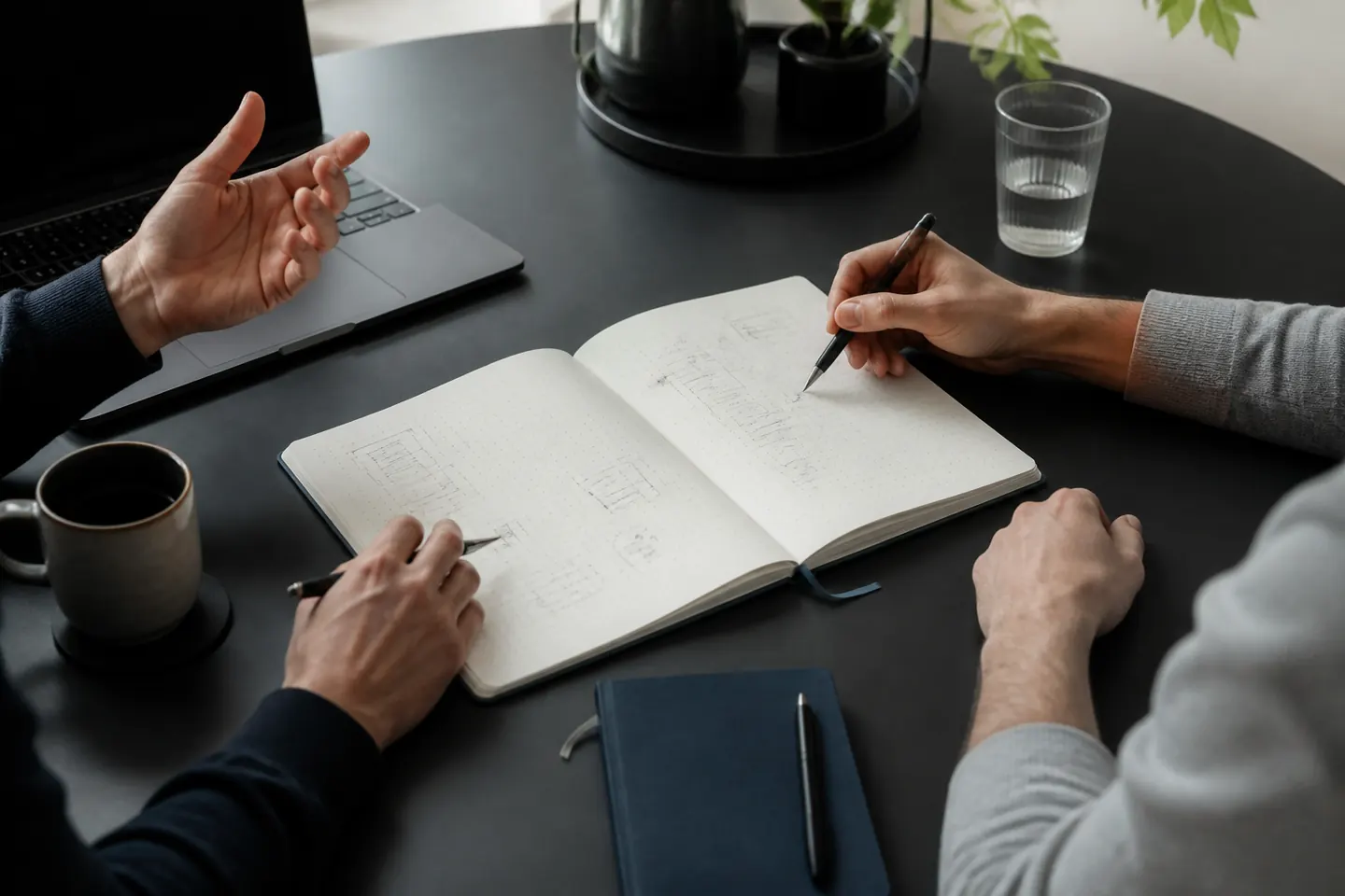 Conversa de descoberta de projeto com notebook e anotações sobre a mesa